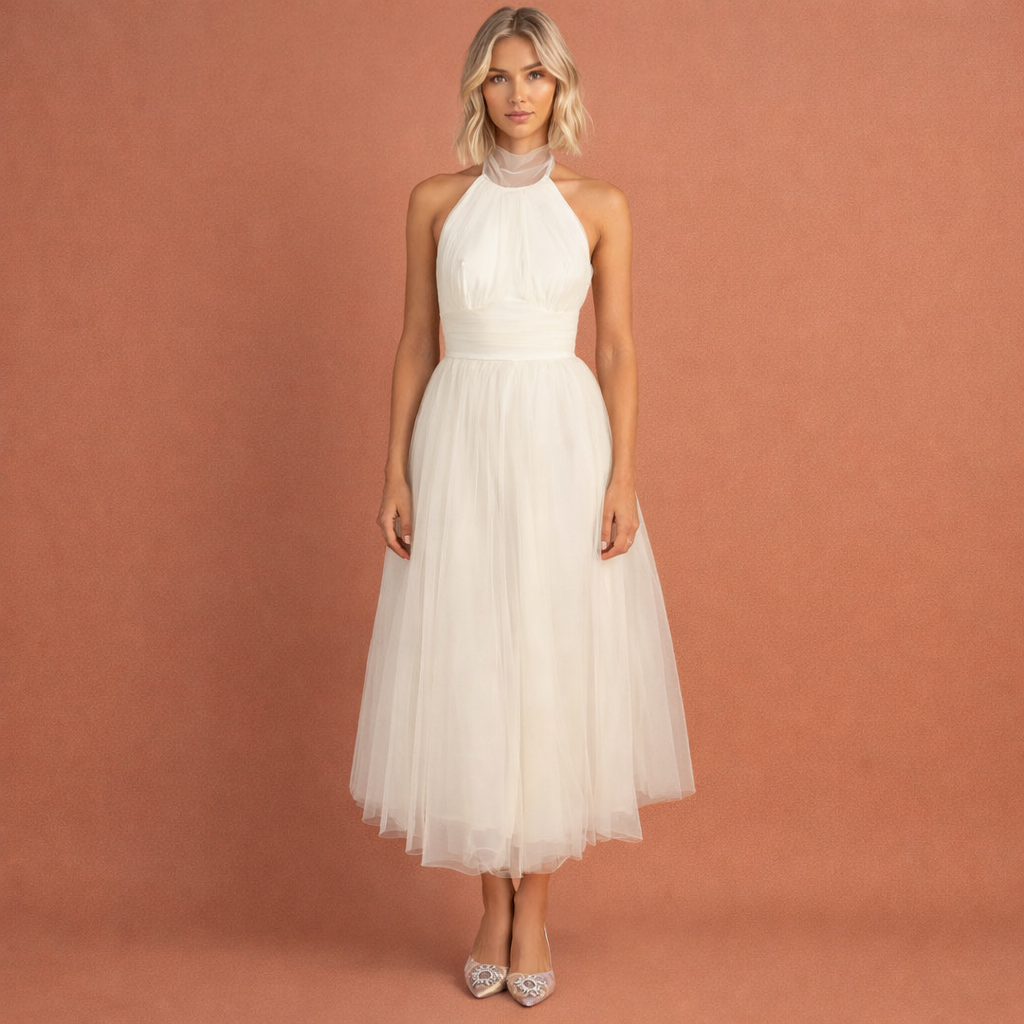 Beige damesjurk met halterhals en gelaagde rok, ideaal voor zomerse en feestelijke gelegenheden.