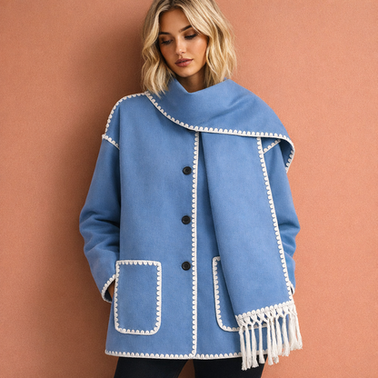 Blauwe elegante damesjas met ruime pasvorm en bijpassende sjaal, ideaal voor stijlvolle outfits tijdens koude dagen.